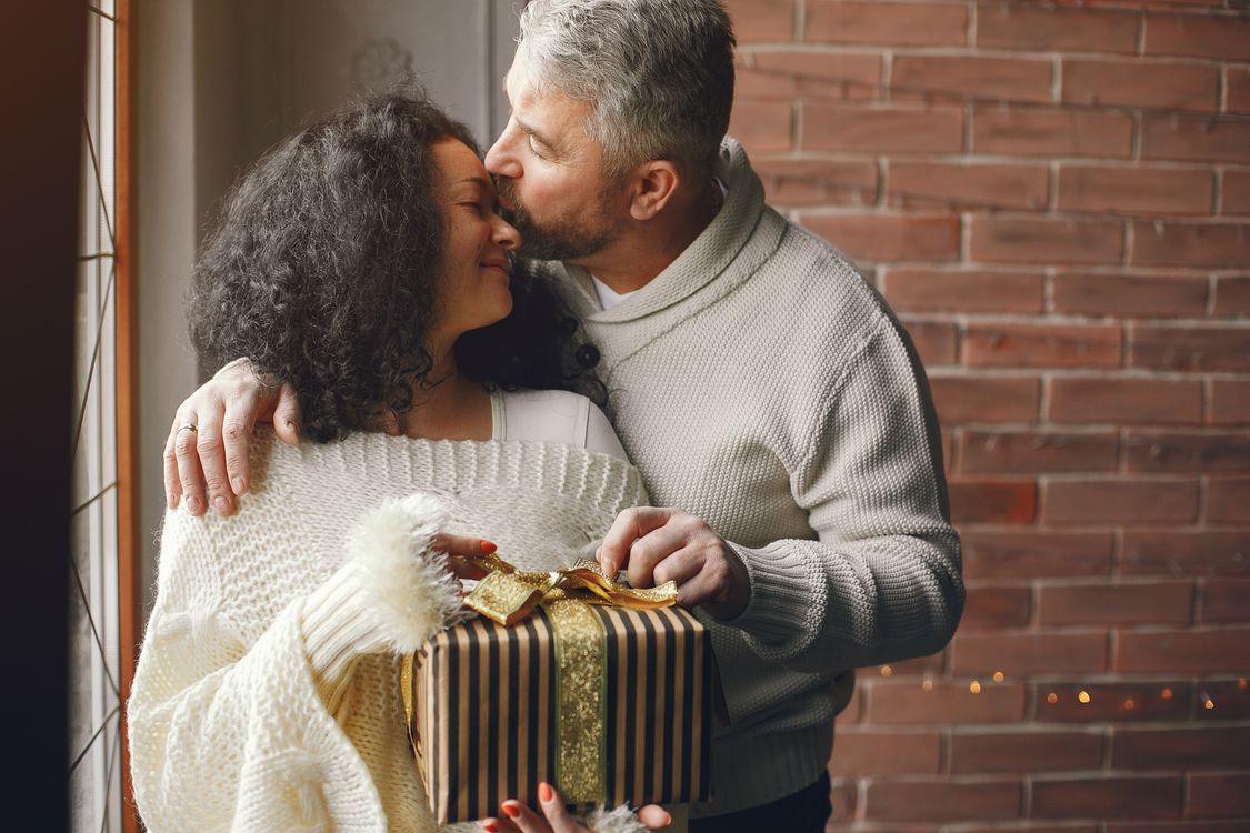 Casal trocando presentes de Natal com romantismo