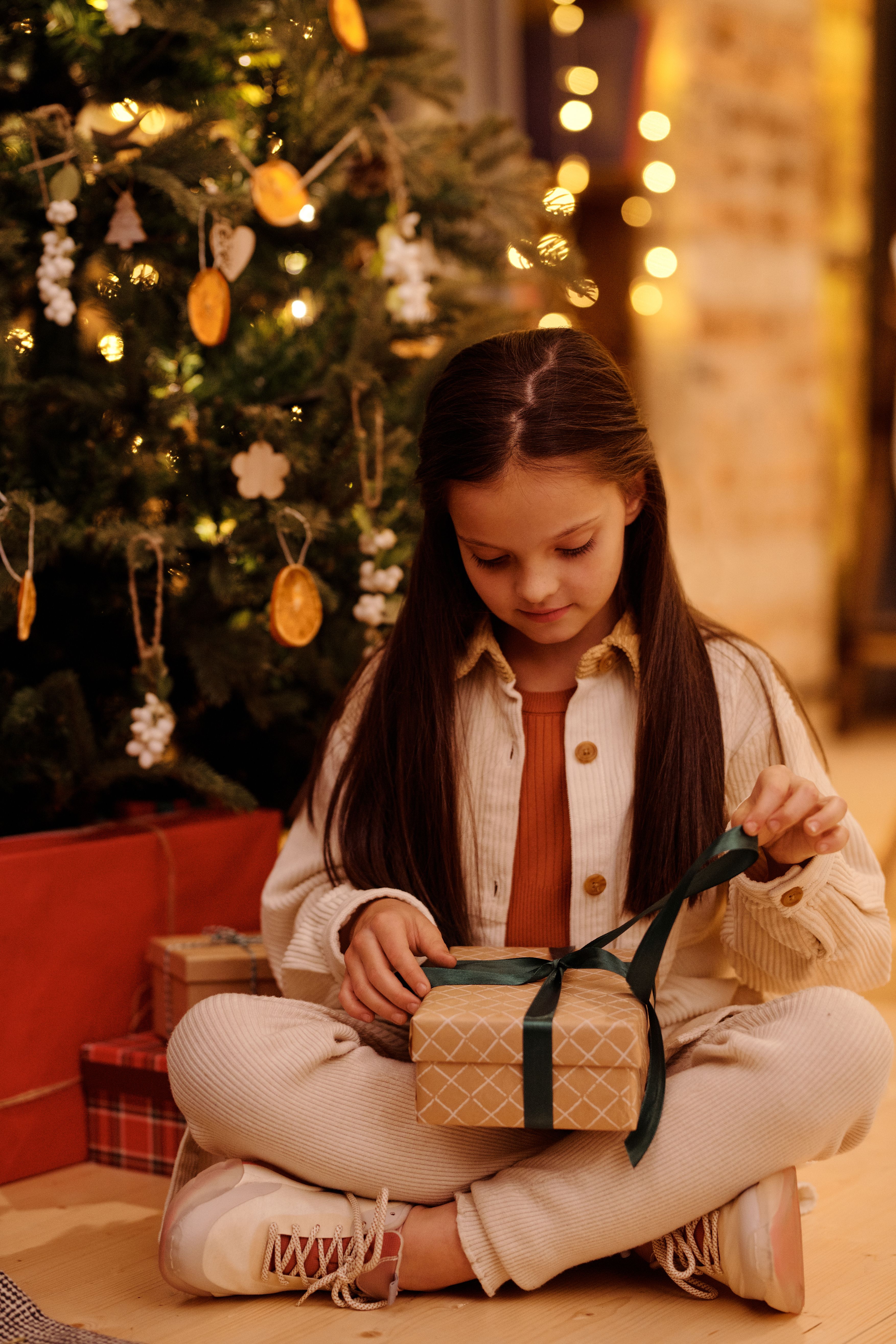 Criança abrindo presentes de Natal com a família