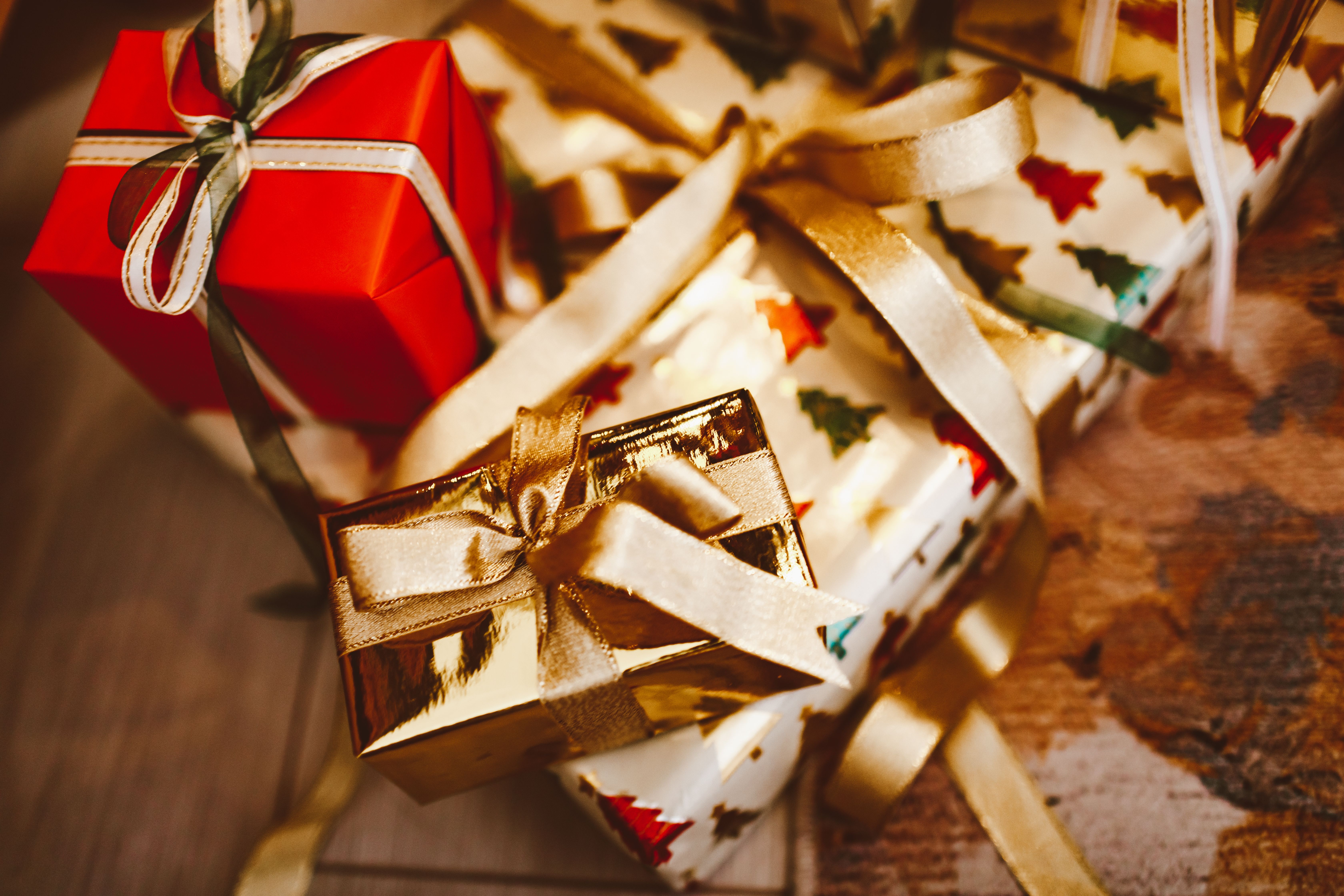 Presentes de Natal embrulhados com laços dourados e luzes festivas